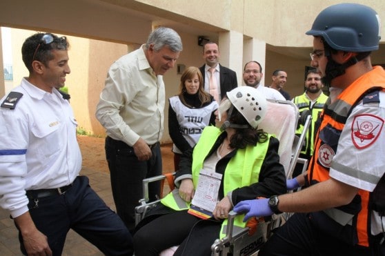 ראש העיר צביקה גנדלמן מרגיע פצועה שפונתה מזירת הטיל