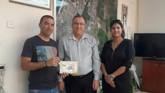 אלי דוקורסקי ראש עיריית קרית ביאליק (במרכז) מעניק את הפרס לגונן כהן (צילום באדיבות העיריה)