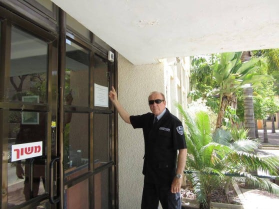 ג'רי שרון, עובד עמדת המודיעין, מדגים את ההתקנה ללקויי ראייה מעל לדלת הכניסה לבניין (צילום: דוברות עיריית קרית ביאליק)