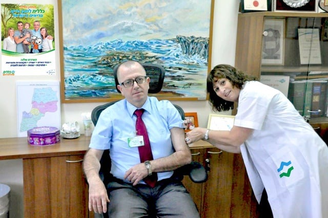 ד"ר זאהי סעיד מקבל חיסון מרחל שמר. (צילום: דוברות כללית)