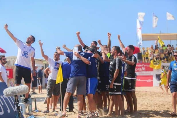 סלפי עם כוכבים. שחקני כרמיאל חוגגים על החול את עלייתם לחצי הגמר (צילום: אופיר זגורי)