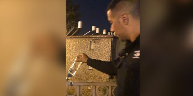 שוטר שופך האלכוהול שנתפס (צילום דוברות המשטרה)
