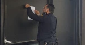 שוטר מדביק צו סגירה למועדון (צילום דוברות המשטרה)