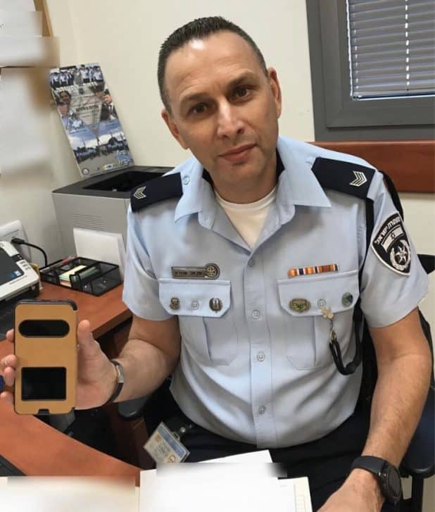 השוטר ישראל שוורץ וטלפון שהוחזר לבעליו (צילום דוברות המשטרה)