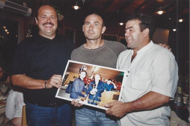 אבא יוסי ליקוורניק (משמאל) והאוהד יעקב ממן מעניקים שי למאמן מוטי איווניר בעונת העלייה